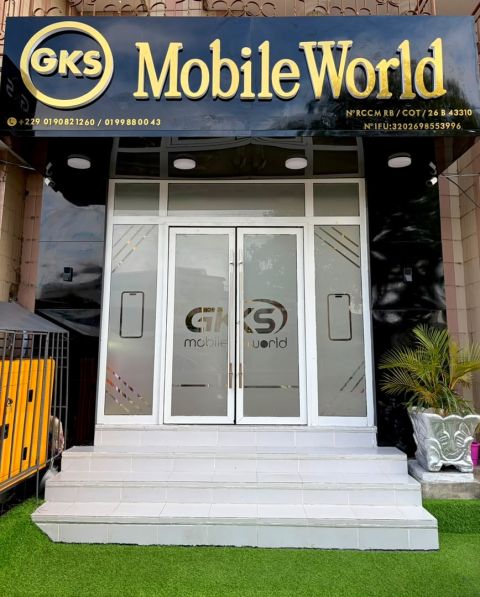 L'entrée de GKS Mobile World de jour : enseigne noire et or, double porte vitrée au logo, marches blanches