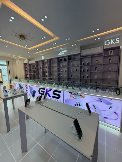 Le mur de téléphones sous les enseignes Apple et Samsung, les tables d'essai au premier plan